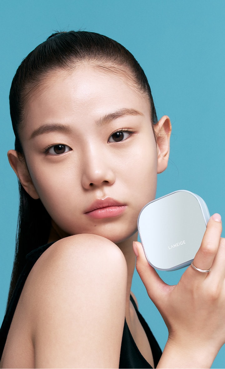 A model holding Neo Cushion Mewy while gazing straight ahead